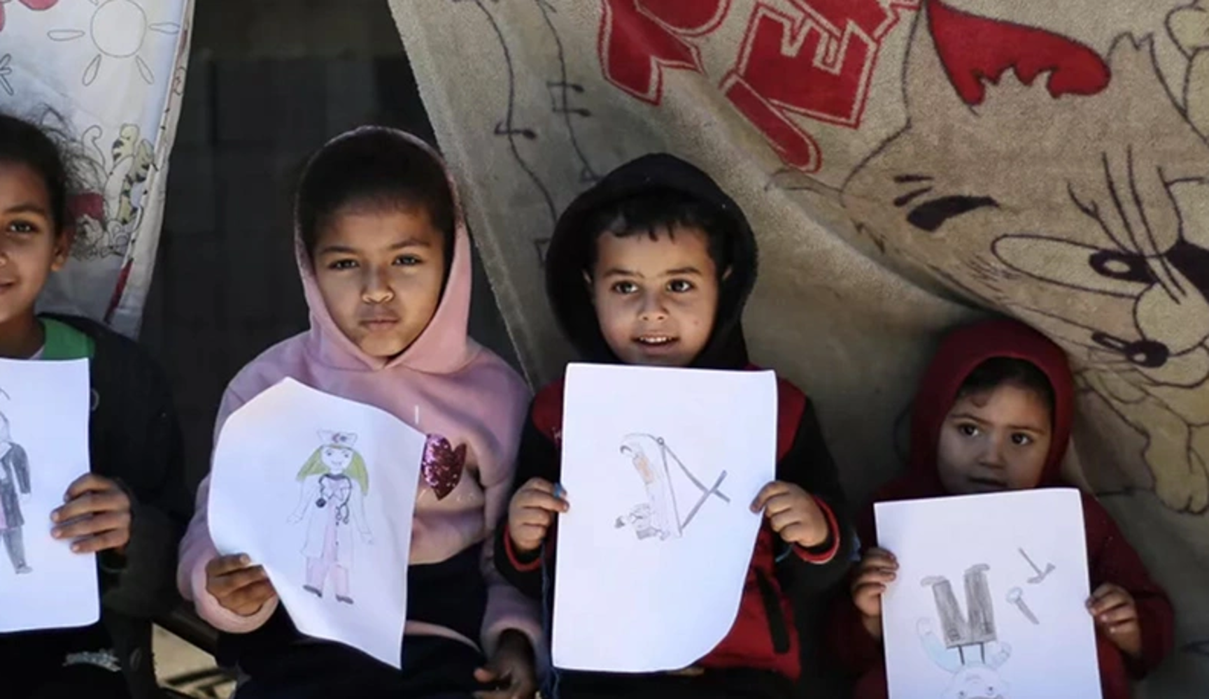 children holding their drawings