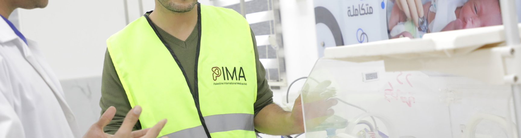 PIMA staff beside neonatal care equipment